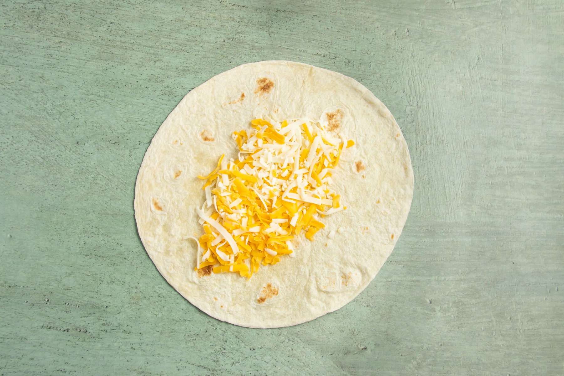 This is a picture of a large tortilla with cheese.