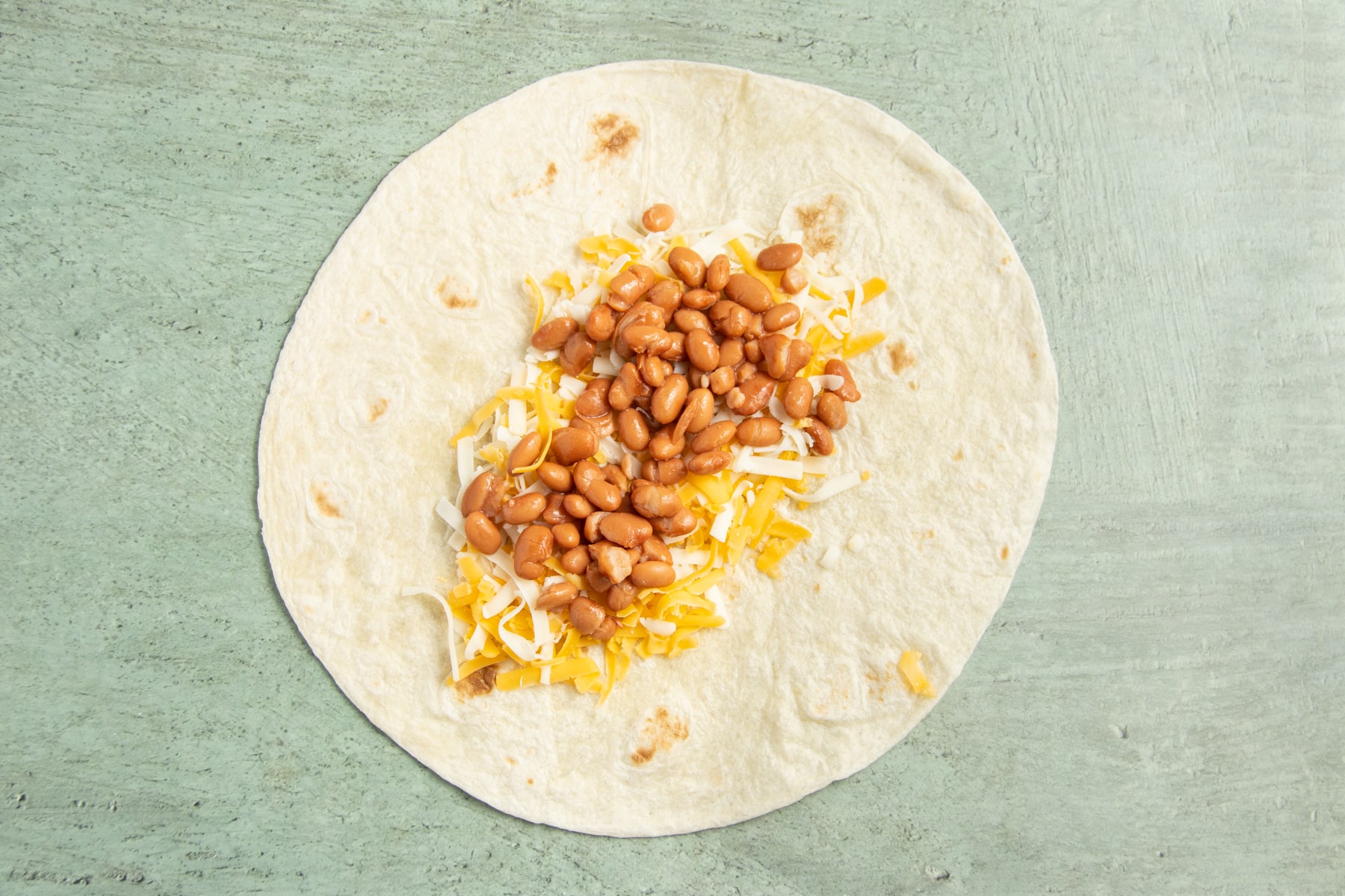 This is a picture of a large tortilla with beans added.