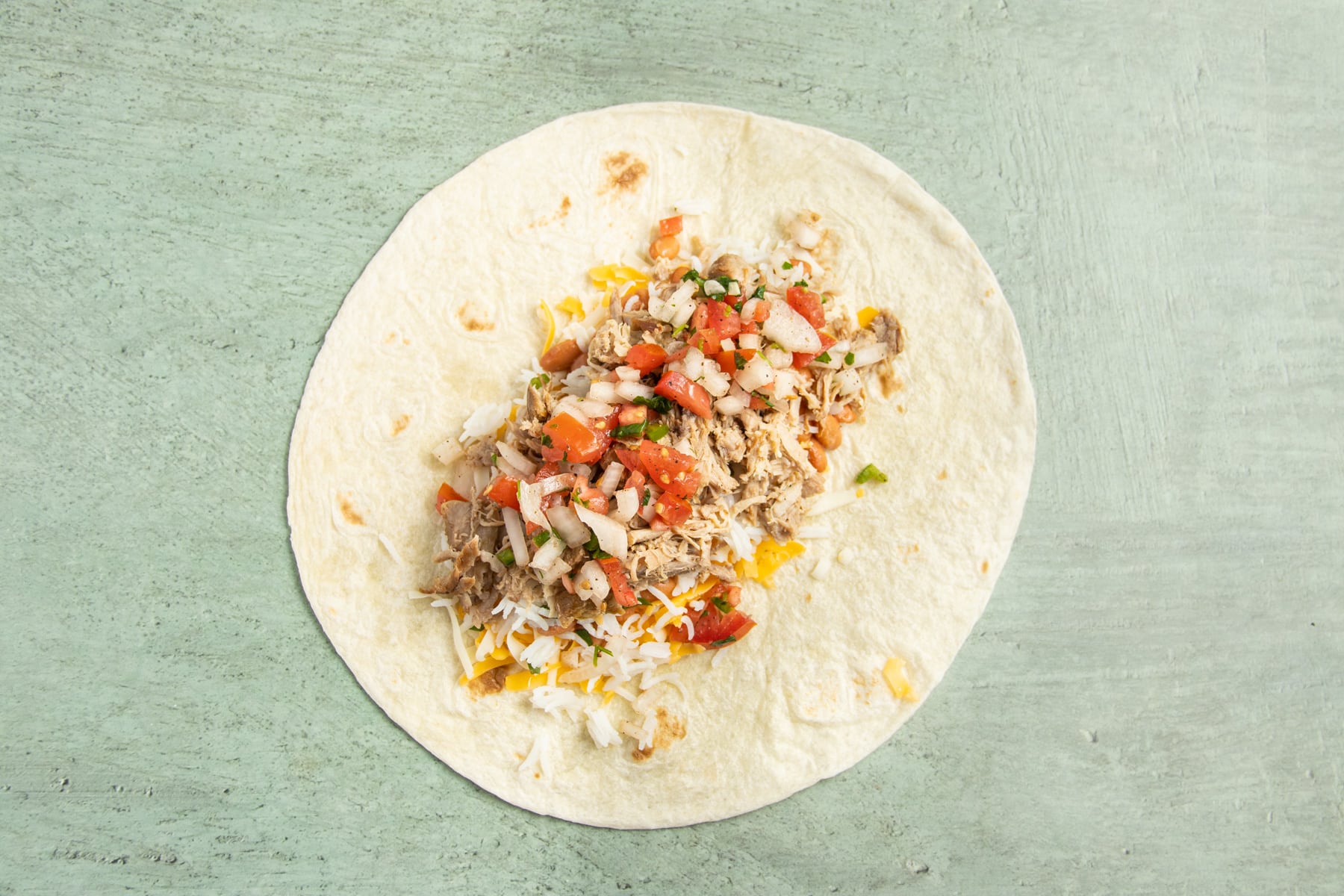 This is a picture of a large tortilla with salsa fresca added.
