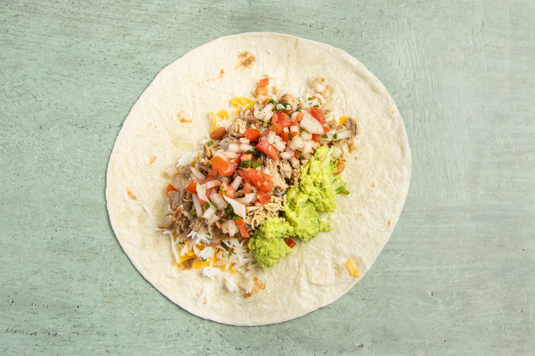 This is a picture of a large tortilla with guacamole added.