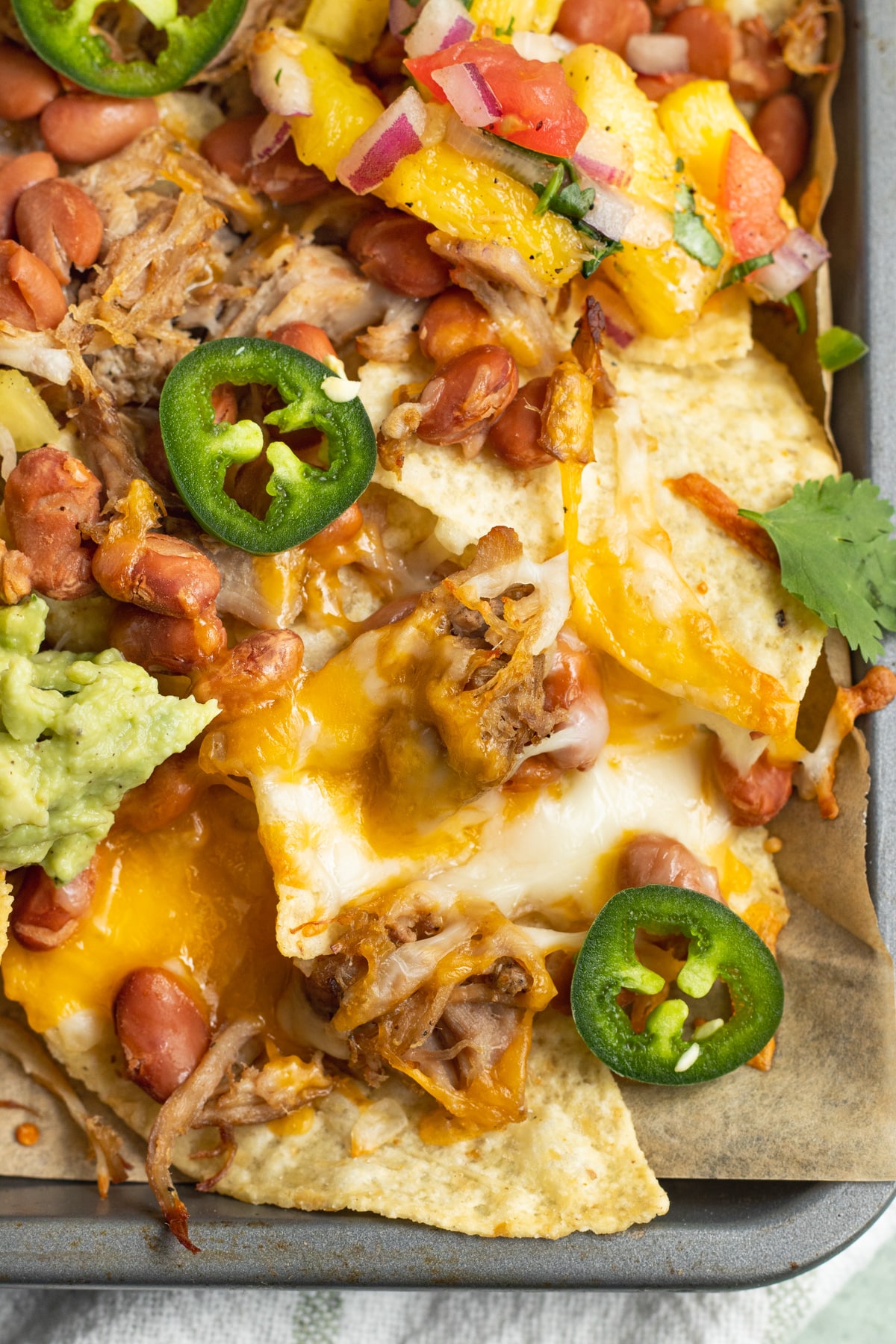 This is a picture of a close-up of loaded carnitas nachos.