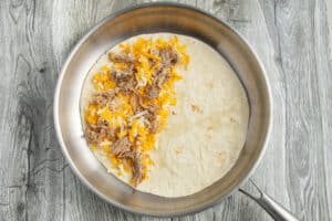 This is a picture of a skillet with a quesadilla being cooked.