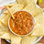 This is a picture of a bowl of roasted red salsa with chips