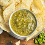 This is a picture of a bowl of roasted tomatillo salsa with chips