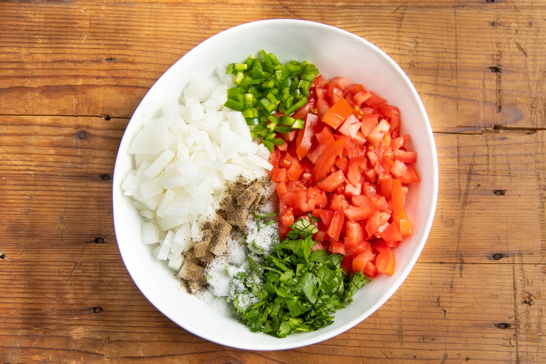 This is a picture of the ingredients chopped finely in a bowl with seasoning.