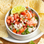 This is a picture of a bowl of salsa fresca with chips.