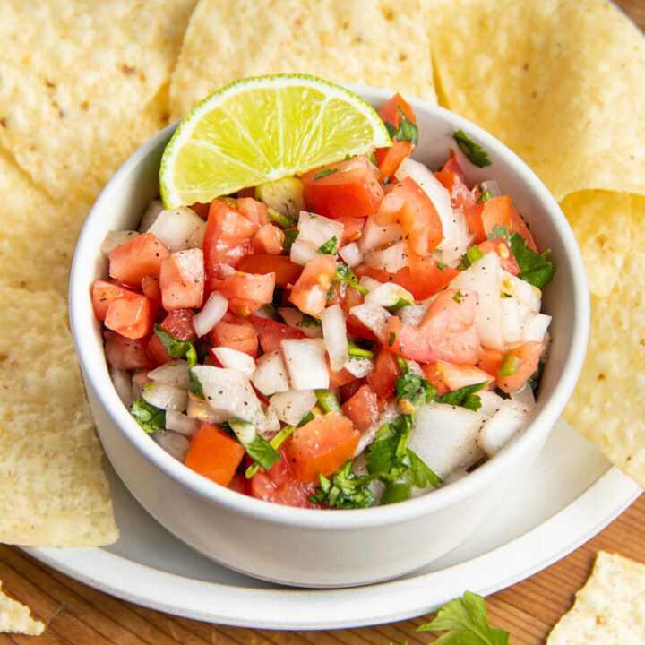 This is a picture of a bowl of salsa fresca with chips.