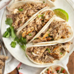 This is a picture of tacos filled with slow cooker pork carnitas.