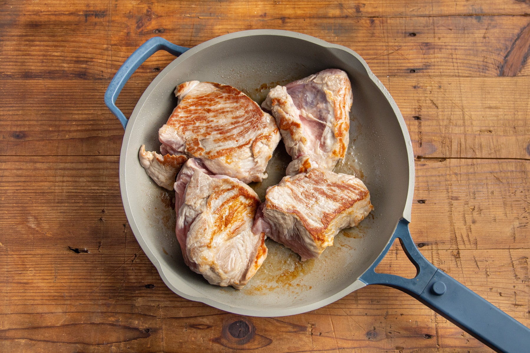 This is a picture of the pork getting seared in a skillet.