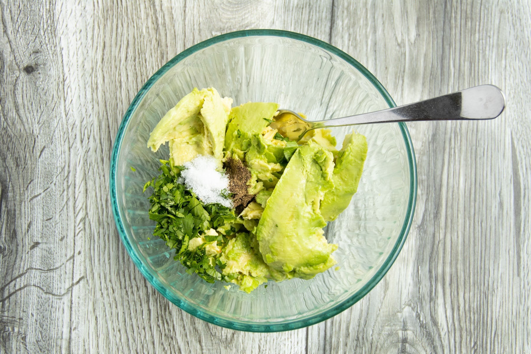 This is a picture of a bowl with all the ingredients to make this guacamole.