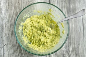 This is a picture of a bowl with all the ingredients mashed to make this guacamole.