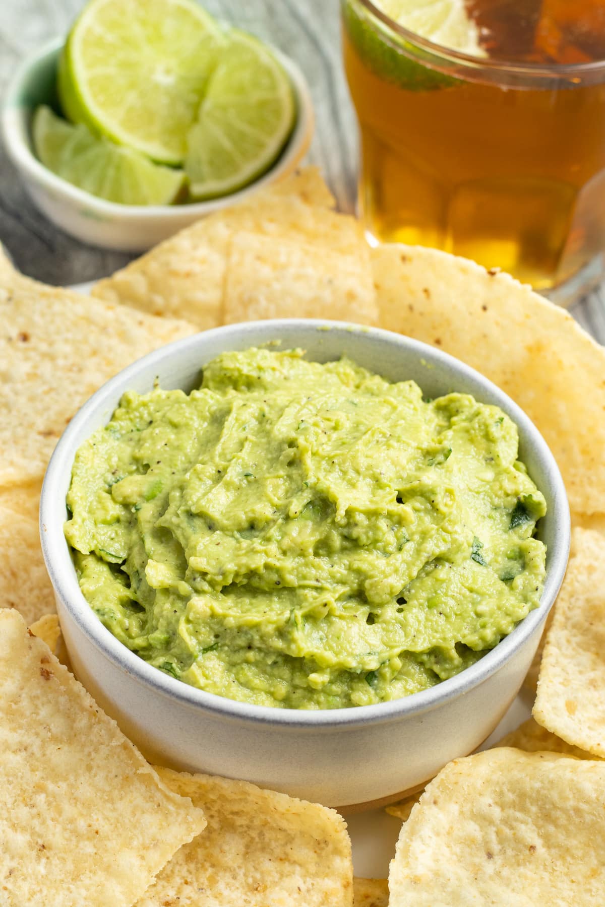 This is a picture of a bowl of guacamole with tortilla chips.