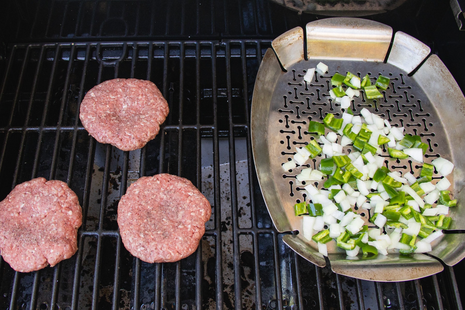 This is a picture of the patties and veggies on the grill.