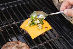 This is a picture of the grilled onion and jalapeño added on top of the slice of cheese.