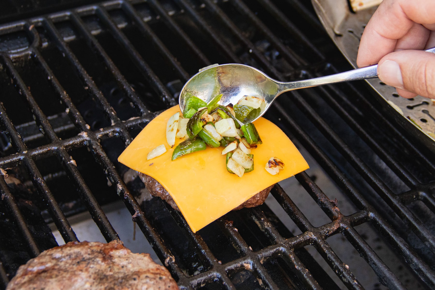This is a picture of the grilled onion and jalapeño added on top of the slice of cheese.