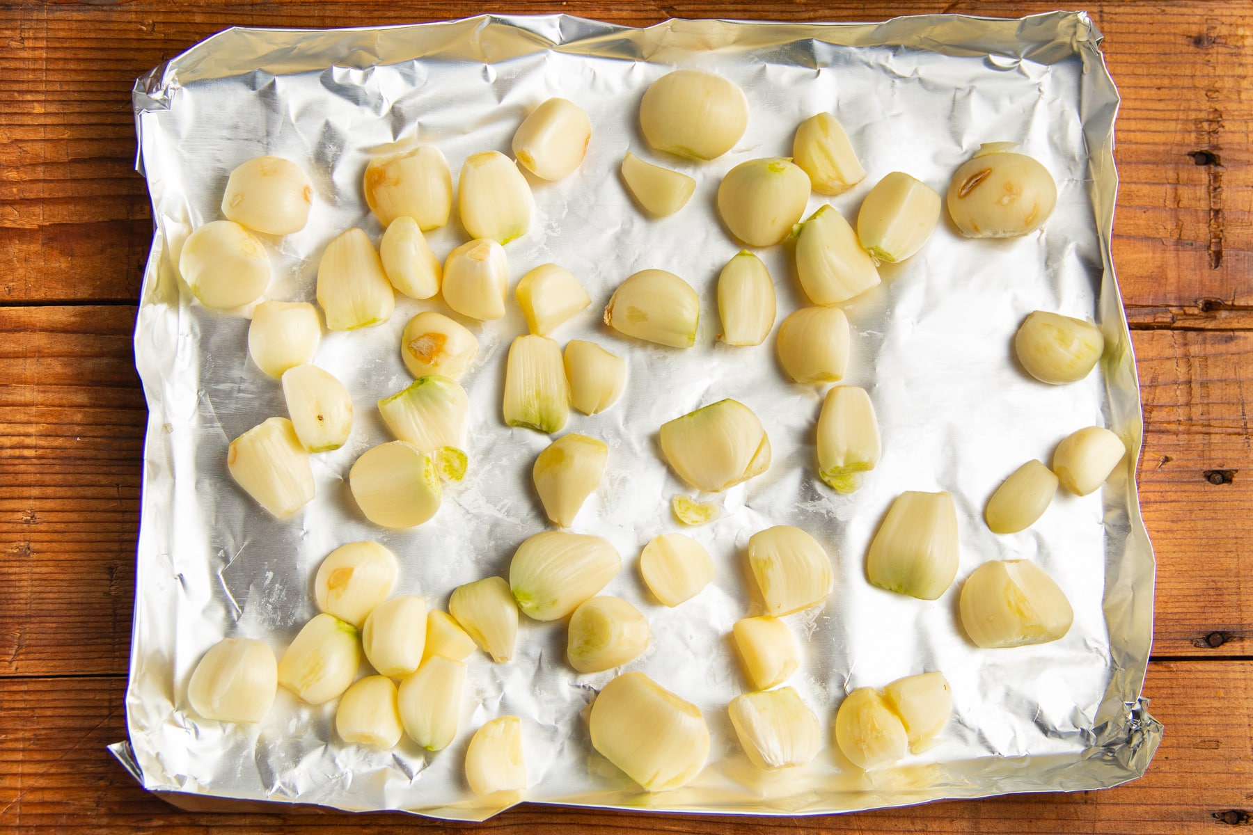 This is a picture of garlic cloves on a baking sheet.