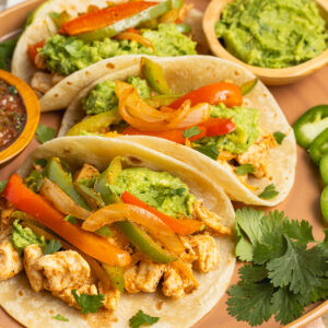 This is a square photo of chicken fajita tacos.