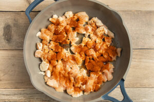 This is a picture of a skillet with chicken cooking.